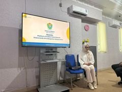 Anggota tim memaparkan Prakira di depan layar presentasi.